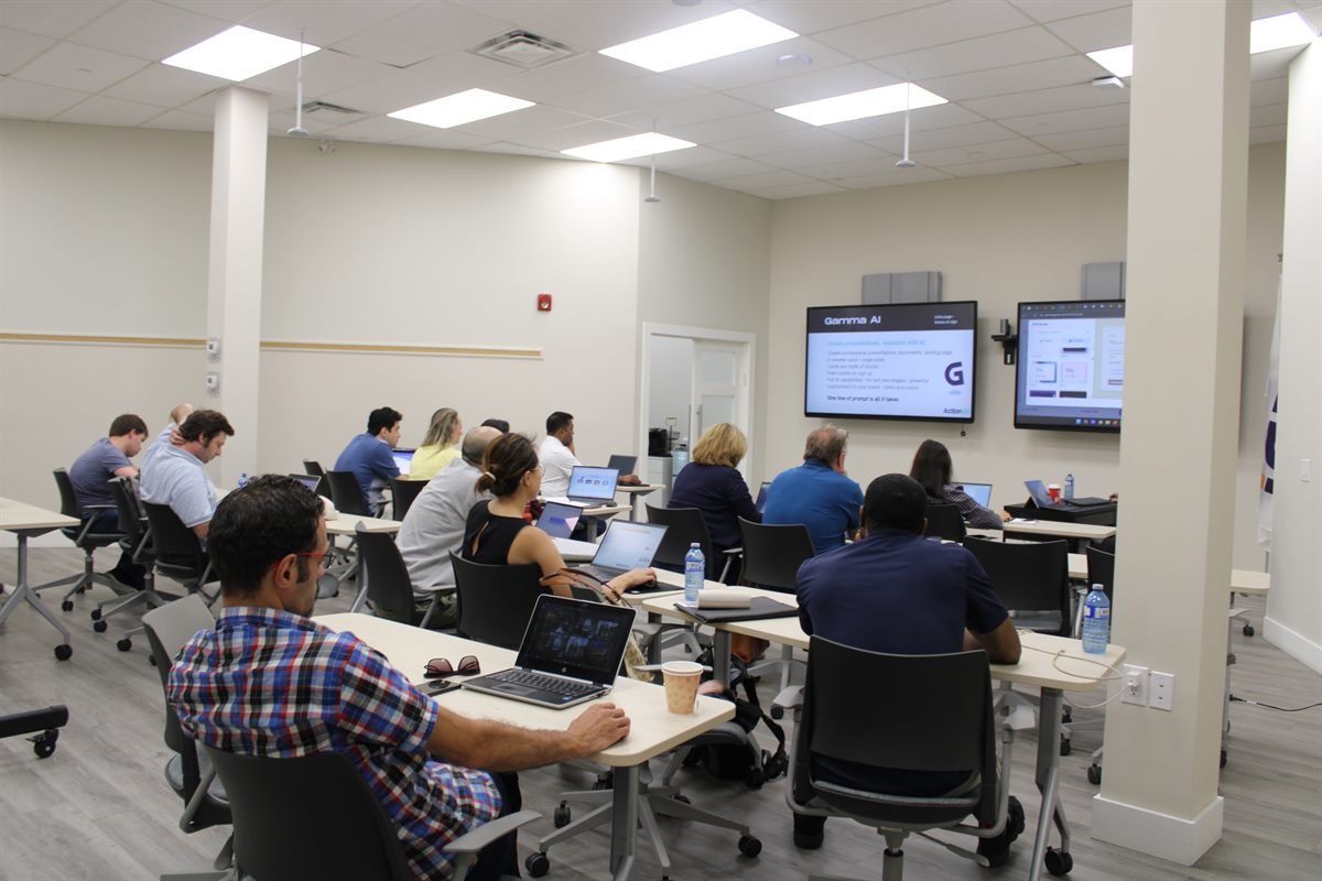 A full training room working through AI tools on their own laptops