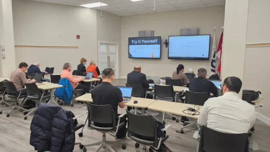 Team members working hands on with AI on their own laptops